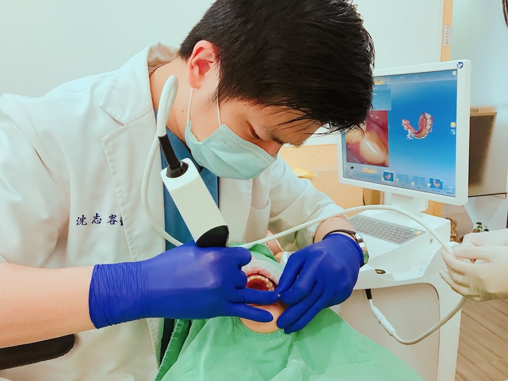 瓷牙貼片價格-牙齒貼片缺點-牙齒美白推薦診所選擇-沈志容醫師操作口掃機進行掃描-掃描畫面會即時顯示在螢幕上